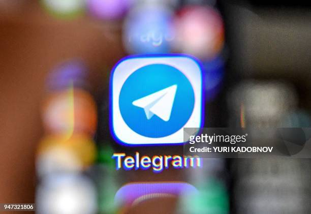 An illustration picture taken through a magnifying glass on April 17, 2018 in Moscow shows the icon of the popular messaging app Telegram on a smart...
