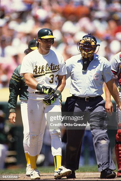 Jose Canseco of the Oakland Athletics speaks with an umpire during a game at Oakland Coliseum in Oakland, California.