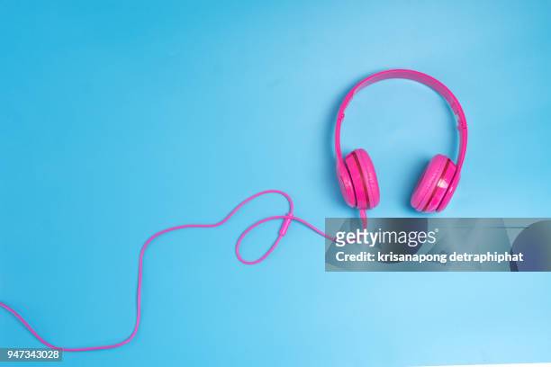 headphones on blue background - bluetooth stock pictures, royalty-free photos & images