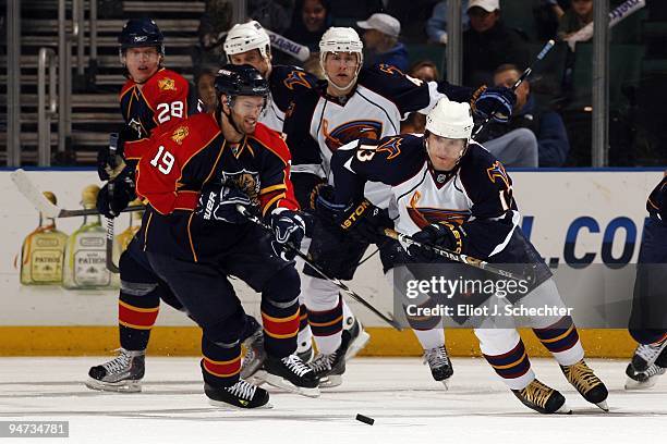 Dominic Moore of the Florida Panthers skates for the puck against Vyacheslav Kozlov of the Atlanta Thrashers at the BankAtlantic Center on December...