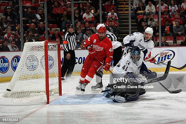 Steven Stamkos of the Tampa Bay Lightning, teammate Lukas Krajicek and Mike Smith watch the puck as Henrik Zetterberg of the Detroit Red Wings skates...