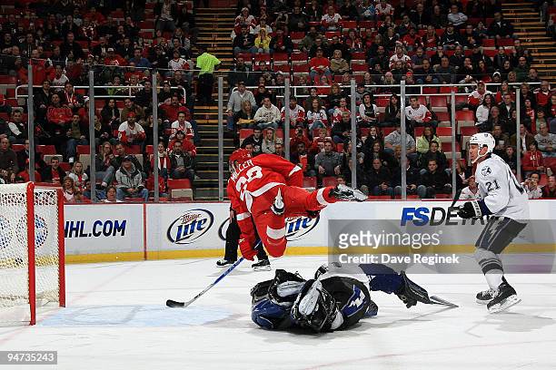 Drew Miller of the Detroit Red Wings takes a shot mid-air and scores as David Hale of the Tampa Bay Lightning watches the puck and teammate Mike...