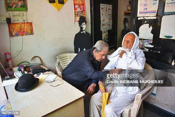 In this photograph taken on April 16 Ashok Aswani , an ayurvedic doctor and founder of the Charlie Circle fan club, checks a patient at his...