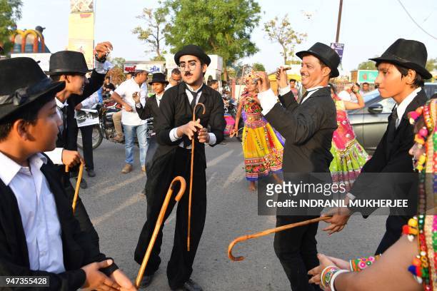 In this photograph taken on April 16 Talin Mavani , a Charlie Chaplin impersonator, breaks into a jig with other impersonators during an event...