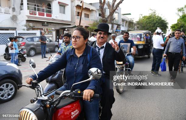 In this photograph taken on April 16 Ashok Aswani, an ayurvedic doctor and founder of the Charlie Circle fan club, waves to bystanders as his...