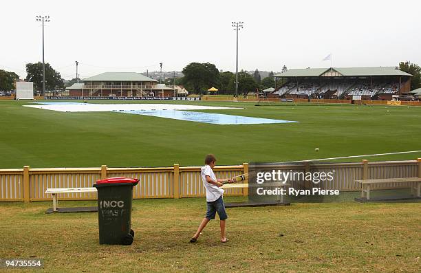 Kids play cricket on the hill as rain delays the start of play during day one of the Sheffield Shield match between the New South Wales Blues and the...