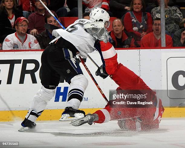 Henrik Zetterberg of the Detroit Red Wings falls to the ice as he gets checked by Mattias Ohlund of theTampa Bay Lightning during a NHL game at Joe...