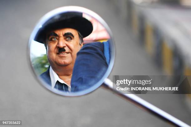 In this photograph taken on April 16 Ashok Aswani, an ayurvedic doctor and founder of the Charlie Circle fan club, is reflected in a mirror as his...