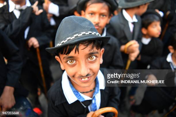 In this photograph taken on April 16 a young Charlie Chaplin impersonator poses for a picture during an event commemorating the legendary actor's...