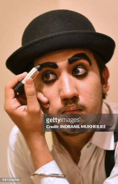In this photograph taken on April 16 2018, Talin Mavani, a Charlie Chaplin impersonator, applies makeup before an event commemorating the legendary...