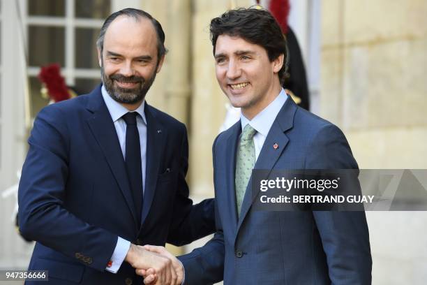 French Prime Minister Edouard Philippe accompanies Canadian Prime Minister Justin Trudeau leaving the Hotel Matignon in Paris, on April 17 after...