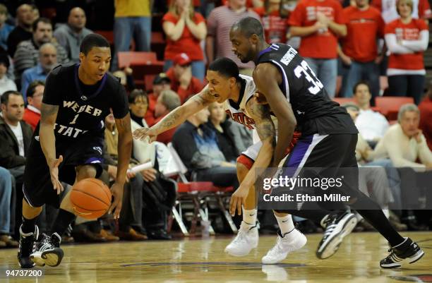 Tre'Von Willis of the UNLV Rebels goes for a steal between Damian Lillard and Matt Washington of the Weber State Wildcats during their game at the...