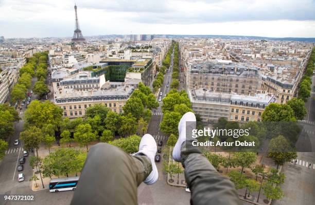 guy legs from helicopter view with stunning paris cityscape. - vertigo foto e immagini stock