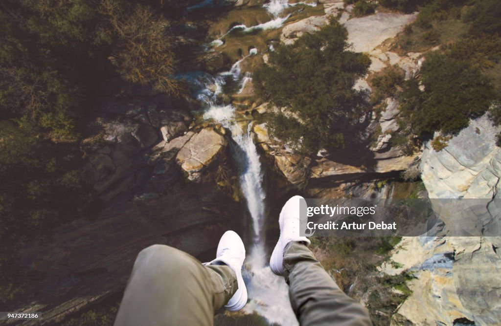 Guy legs from helicopter view with stunning waterfall landscape.