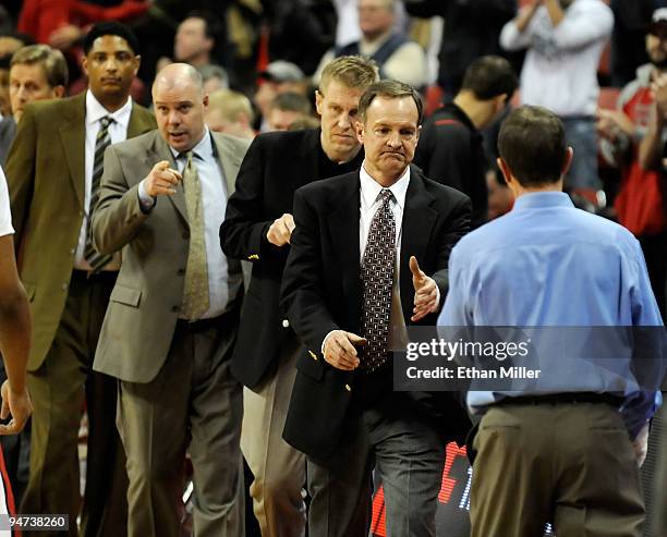 Rebels assistant coaches Lew Hill and Steve Henson, director of basketball operations Mike Shepherd and head coach Lon Kruger line up to shake hands...