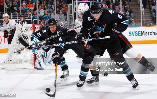 Joe Pavelski of the San Jose Sharks battles his opponent while linemate Rob Blake reaches in to snatch the puck during an NHL game against the...