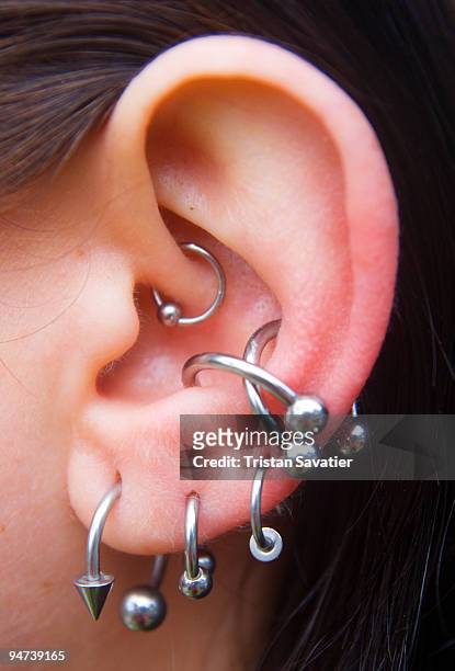 ear piercings and body jewelry - ear close up women stockfoto's en -beelden