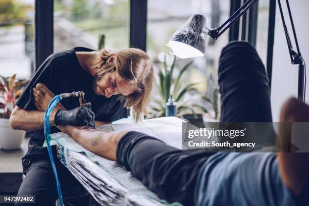 guy getting a leg tattoo - surgical suture stock pictures, royalty-free photos & images