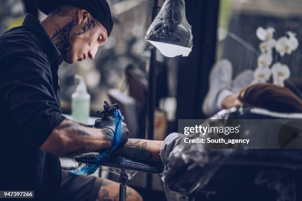 tattoo artist working - tattoo spectacular stock pictures, royalty-free photos & images