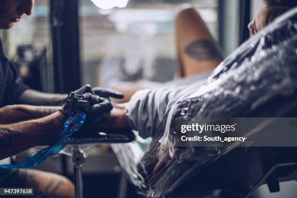 getting a tattoo on arm - surgical suture stock pictures, royalty-free photos & images