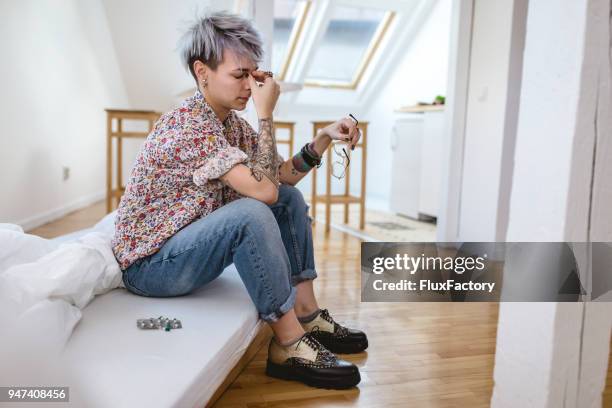 girl sitting on bed in bad health - lesbian bed stock pictures, royalty-free photos & images