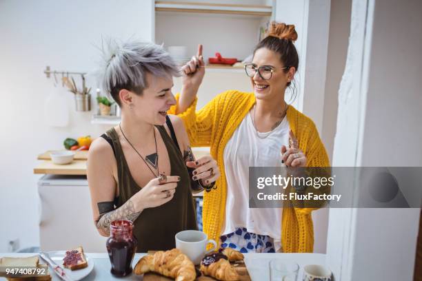 lesbisch koppel dansen en eten ontbijt - couple dancing at home stockfoto's en -beelden