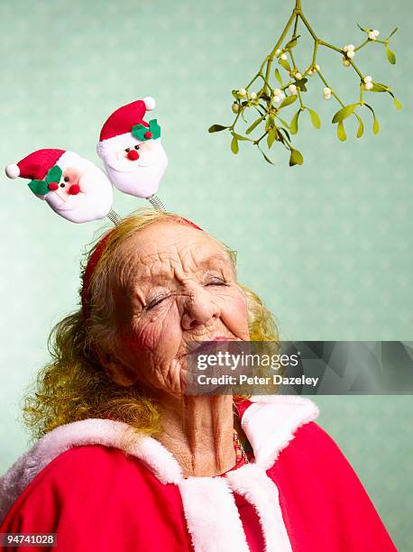 70 year old mother in law under mistletoe. - haarreifen mit sternchen stock-fotos und bilder