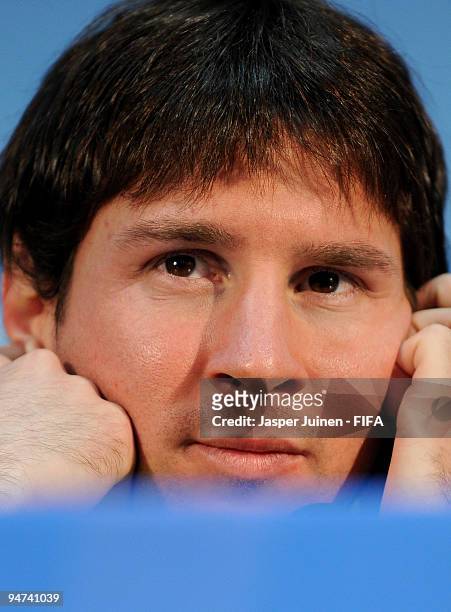 Lionel Messi of FC Barcelona listens to questions from the media during a press conference at the Zayed Sports City stadium on December 18, 2009 in...