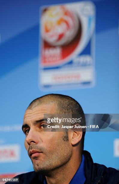 Head coach Josep Guardiola of FC Barcelona listens to questions from the media during a press conference at the Zayed Sports City stadium on December...
