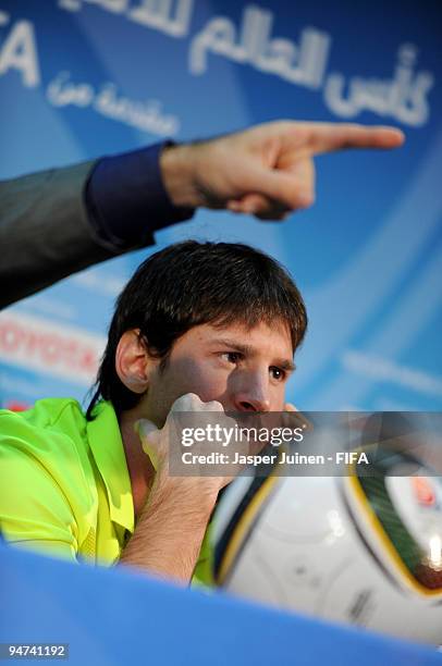 Lionel Messi of FC Barcelona listens to questions from the media during a press conference at the Zayed Sports City stadium on December 18, 2009 in...