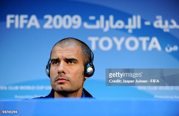 Head coach Josep Guardiola of FC Barcelona listens to questions from the media during a press conference at the Zayed Sports City stadium on December...