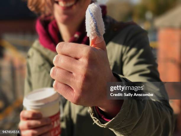 woman with a bandaged thumb - bandaged thumb stock pictures, royalty-free photos & images