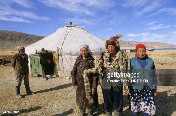 KAZAKH FAMILY SHOWING A SNOW LEOPARD SKIN, MONGOL YURT, ALTAI RANGE, BAYAN OLGII PROVINCE, MONGOLIA.