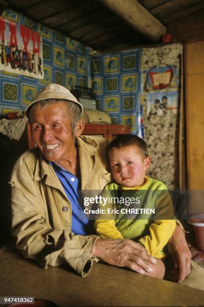 MONGOLIAN GRAND FATHER WITH HIS GRAND SON, BAYAN OLGII PROVINCE, MONGOLIA.