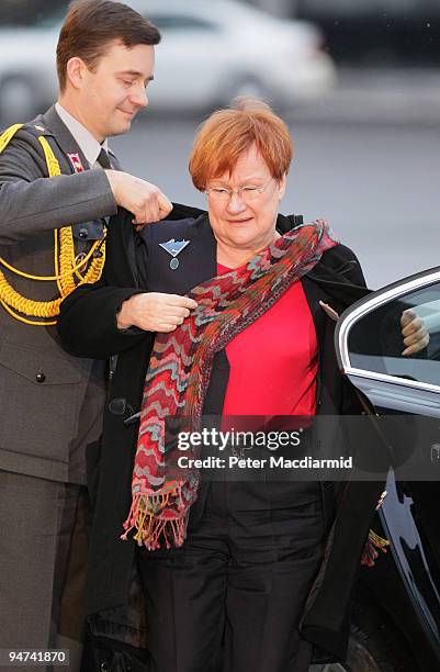 Finland's President Tarja Halonen is helped with her coat by an aid as she arrives for the final day of the UN Climate Change Conference on December...