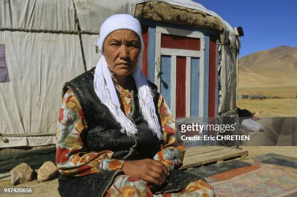 KAZAKH WOMAN IN FRONT OF HER YURT, ALTAI RANGE, BAYAN OLGII PROVINCE, MONGOLIA.