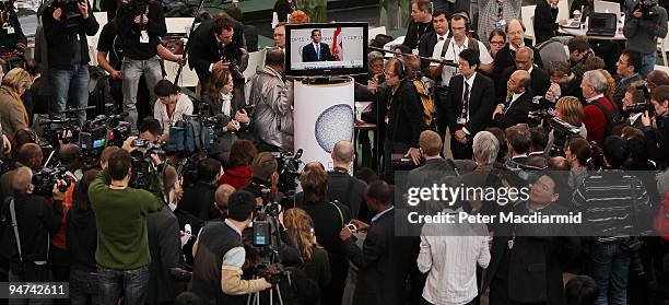 Reporters, photographers and television crews gather round a TV monitor to listen as US President Barack Obama address delegates at the final day of...