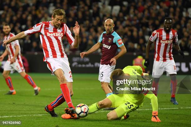 Peter Crouch of Stoke City scores despite the efforts of Joe Hart of West Ham United during the Premier League match between West Ham United and...