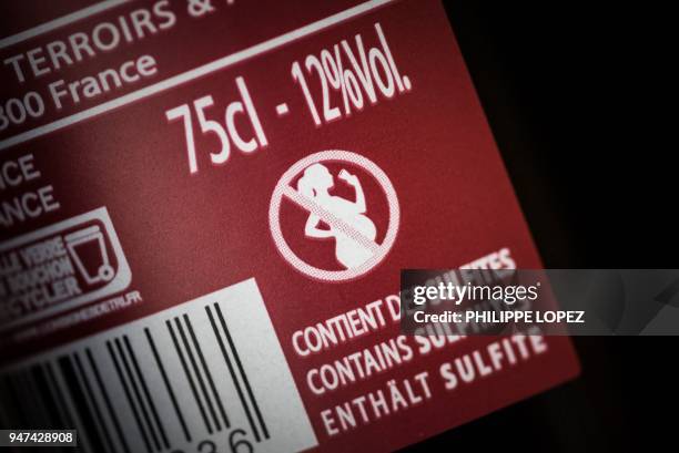 Picture taken on April 17 in Paris shows the label on a French wine bottle with an icon picturing a forbidden sign on a pregnant woman drinking. -...