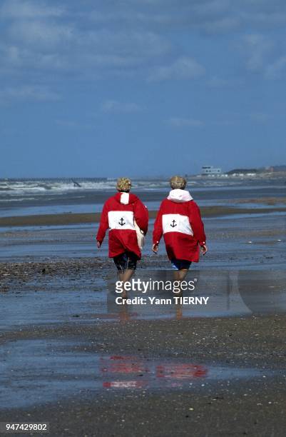 Jumelles en promenade a maree basse, Plage d'Oostduinkerke, Cote Belge, Belgique.