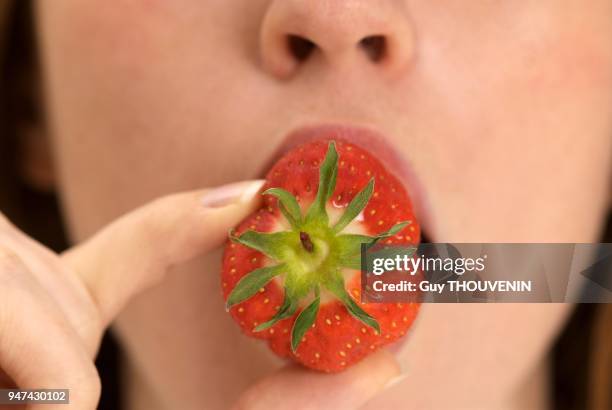 Femme mangeant une fraise.