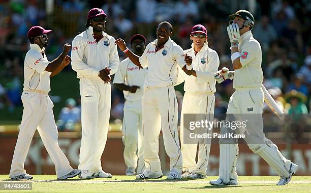 Chris Gayle and Dwayne Bravo of the West Indies celebrate with team mates after the dismissal of Michael Clarke during day three of the Third Test...