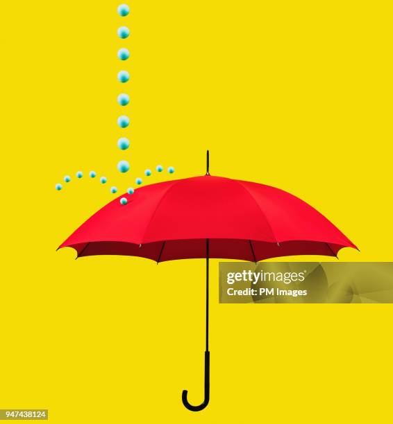 symbolic rain drops falling on red umbrella - umbrella protection stock pictures, royalty-free photos & images