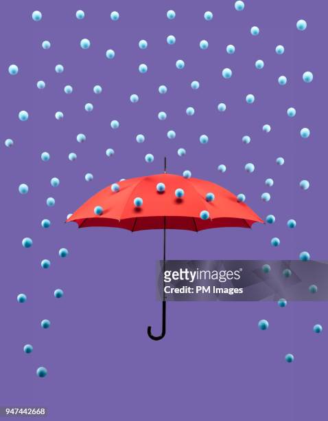 symbolic rain drops falling on red umbrella - afweren stockfoto's en -beelden