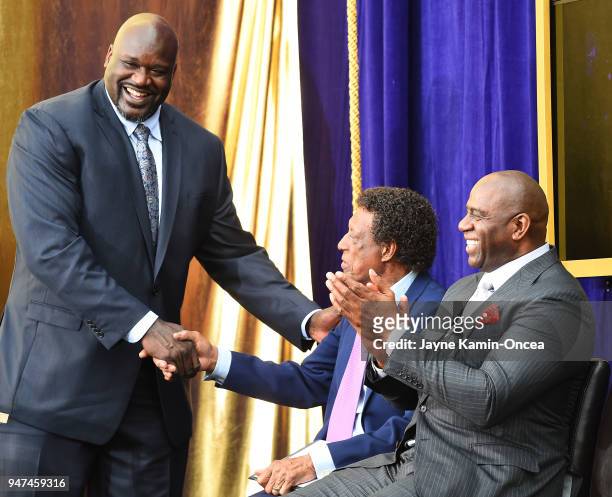 Los Angeles Lakers Ervin Magic Johnson applaudes as Shaquile O'Neal shakes hands with Hall of Famer Elgin Baylor during the unveiling ceremony for...
