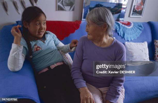 Andusa Larsen, accompanied by one of her two granddaughters, in the living room of her house in Tasiilaq /65? 36' North - 37? 37' West, in July 2006....