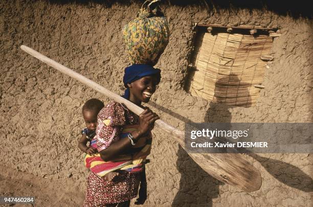 Mangrove de Guinée. Jeune femme Balante rends visite au village Baga de Marara, région de Boffa. L'enfant qu'elle porte dans son dos est d??c??d??...