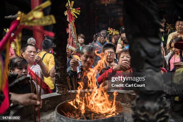 Pilgrims burn incense sticks in Xingang Fengtian Temple where the statue of Mazu will rest for two nights before resuming its journey, on day four of...