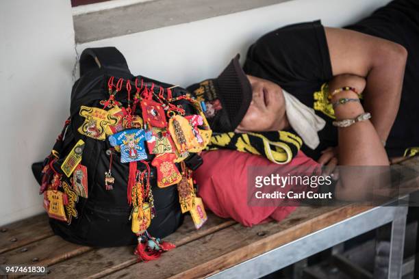 Man sleeps at a pilgrims rest house next to his bag that has been decorated with badges of Mazu near Xingang Fengtian Temple where a statue of Mazu...