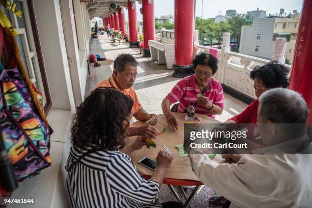 People play a traditional game at a pilgrims rest house near Xingang Fengtian Temple where a statue of Mazu is being displayed before continuing the...